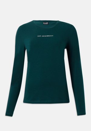 Tumši zaļš garām piedurknēm krekls ar apaļu izgriezumu un balto "EA7 Emporio Armani" logotipu centrā uz balta fona.