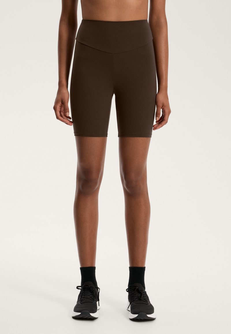 Bruna högmidjade cykelshorts i stretchmaterial, med en figurnära design, slät yta och knälång längd.