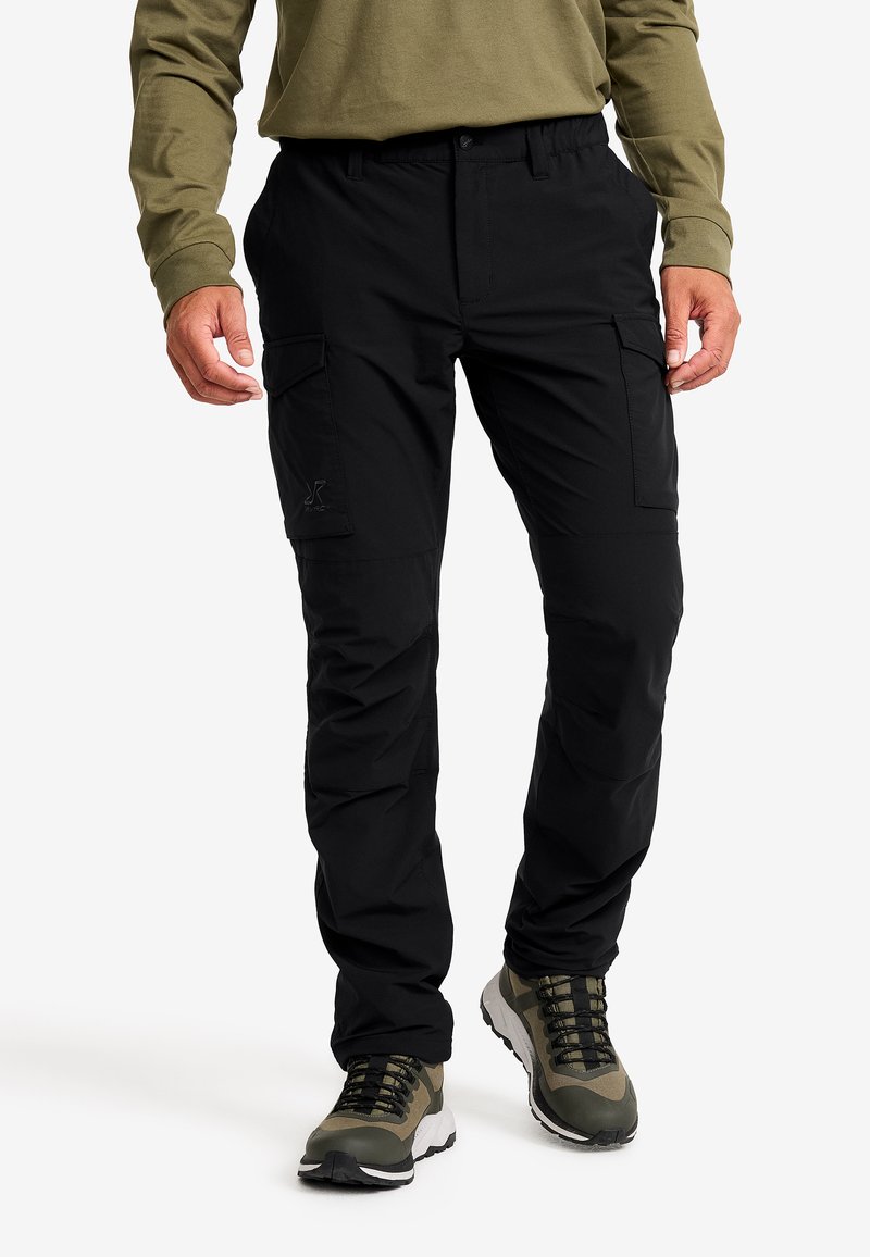 Black cargo pants made of a durable material, featuring side pockets, a relaxed fit, and a smooth texture, paired with green hiking shoes.