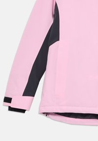 Lyserød og sort jakke med en glat tekstur, der har en lynlås, sidelommer og kontrasterende farvepaneler på ærmerne.