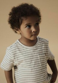 Striped t-shirt in off-white and gray, short sleeves, crew neck, features a small chest pocket and soft texture, modelled by a child.