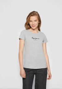 T-shirt in cotone grigio con maniche corte e scollo rotondo. Presenta il logo nero "Pepe Jeans London" stampato sulla parte anteriore.