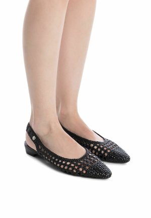 Bailarinas negras trenzadas con punta puntiaguda y laterales abiertos, que cuentan con un pequeño tacón y un acento decorativo. Fabricadas en material sintético.