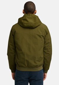 Olivegrüne, leichte Jacke mit Kapuze, elastischen Bündchen und Saum. Glatte Textur und minimalistisches Design ohne sichtbare Verschlüsse oder Taschen.