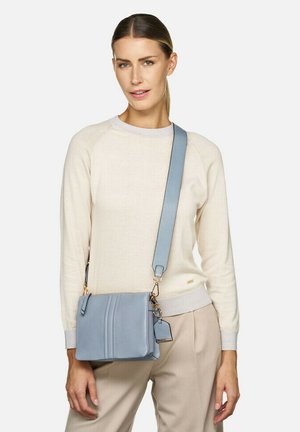 Bolso cruzado de cuero azul claro con acabado texturizado, que cuenta con una correa desmontable, herrajes dorados y dos costuras verticales como detalle de diseño.