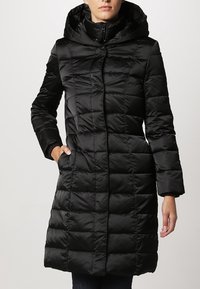 Schwarze Pufferjacke mit Kapuze. Verfügt über ein gestepptes Design, einen Frontreißverschluss, zwei Seitentaschen und lange Ärmel. Glattes, glänzendes Material.