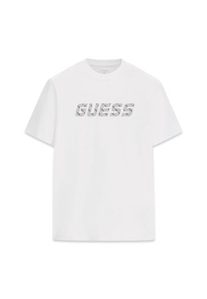 T-shirt en coton blanc avec le mot « GUESS » dans un design graphique à texture imprimée, manches courtes et col rond.