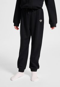 Zwarte sweatpants met een elastische tailleband en enkels, voorzien van een klein geborduurd logo aan de voorkant. Zachte, comfortabele stof.