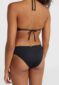 Svart bikini-set med en knytbakad topp och högmidjade trosor. Slät textur med minimala detaljer och en diskret logotyp på midjebandet.