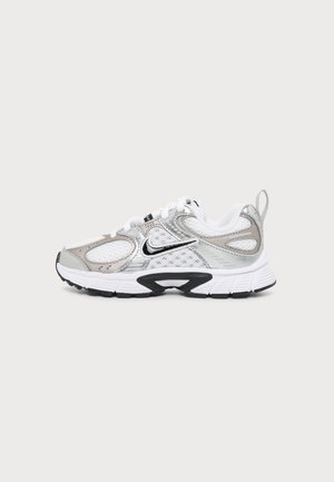 Pantof de alergare Nike alb și argintiu, cu logo swoosh negru, detalii din plasă și talpă texturată, prezentat din lateral pe un fundal simplu.