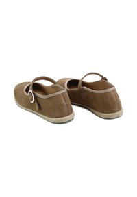 Zapatos de ante marrón con forma redondeada, tacón pequeño y tira decorativa. Presentan costuras contrastantes y una suela ligera de goma.