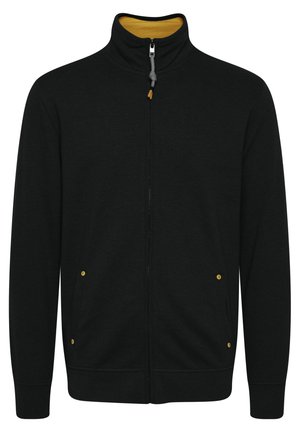 Svart zip-up jacka med hög krage, featuring ett gult innerfoder, sidofickor med gula detaljer och ribbade ärmmuddar.