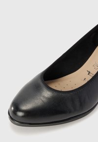 Black leather flat shoe with a rounded toe, smooth outer texture, and soft inner lining. Features minimal stitching and a low-profile design.