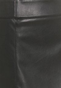 Materiale in pelle nera con una superficie liscia e cuciture visibili. Presenta un design elegante e minimale. Nessun motivo o accento evidente.