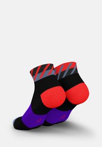 Schwarze Socken mit einem roten und grauen geometrischen Muster an der Oberseite, roten Zehen- und Fersenakzenten sowie einem lila Abschnitt an der Unterseite.