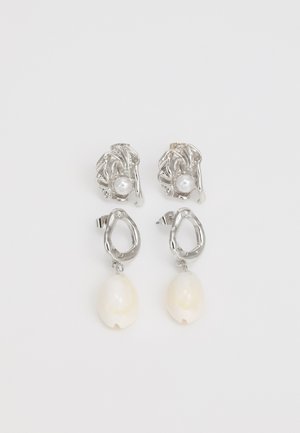 Silberne Ohrringe mit einem strukturierten, abstrakten Design und weißen Perlenakzenten, mit hängenden, cremefarbenen Tropfenformen.