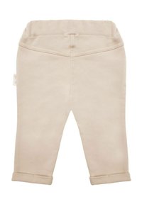 Beżowe spodnie dresowe o miękkiej fakturze, z elastycznym pasem i podwiniętymi mankietami. Gładka tkanina, prosty design, bez widocznych wzorów czy ozdób.