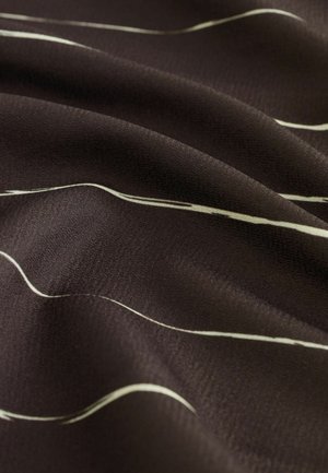 Tissu brun foncé avec une texture douce, présentant de fines lignes blanches ondulées sur la surface. Le motif crée un contraste subtil.