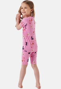Pink pajama set featuring short-sleeve top and shorts, adorned with colorful llama patterns on soft, stretchy fabric.