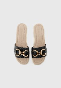Black slide sandals with a textured strap, featuring gold circular hardware. Soft beige footbed with subtle stitching details. Size 37.