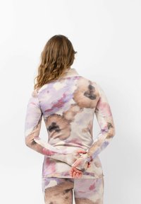 Lange mouw top van zachte, rekbare stof met een pastel aquarel patroon in roze, paars en beige, met duimopeningen bij de manchetten.