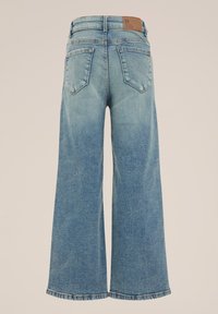 Svijetloplave široke traperice s izbljedenom teksturom, pet džepova i smešnom kožnom oznakom na struku, s ravnim rubom.