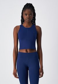 Navy cropped sporttop met een ronde halslijn en racerback ontwerp. Gemaakt van rekbaar materiaal, met platte naden voor comfort.