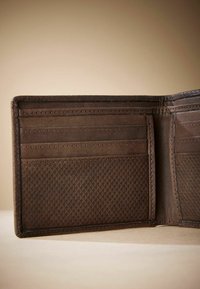 Portefeuille en cuir marron avec plusieurs emplacements pour cartes, intérieur texturé et extérieur lisse. Présente des coutures soignées et un design mince.
