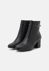 Botas negras hasta el tobillo hechas de cuero suave, con punta cuadrada, tacón ancho y una correa ajustable con un acento de hebilla de metal.