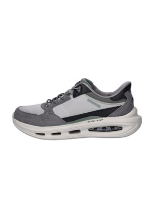 Grauer und weißer Sportschuh mit Schnürung vorne und dicker gedämpfter Sohle mit der Aufschrift Glide-Step, seitlich auf weißem Hintergrund gezeigt.