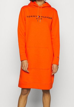 Orangenes Hoodie-Kleid aus weichem Stoff, mit einer Fronttasche, Kapuze mit Kordelzug und Logo-Text auf der Brust in kontrastierenden Farben.