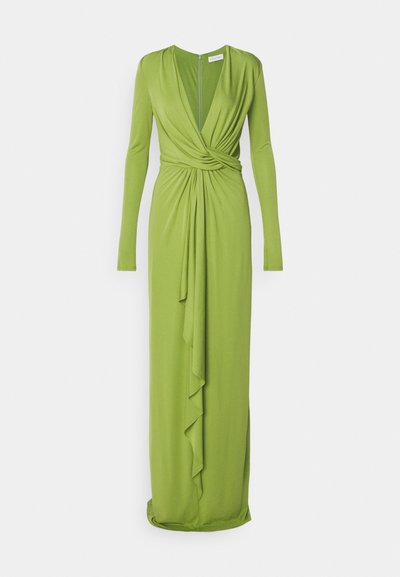 Μακρύ πράσινο φόρεμα από μαλακό ύφασμα. Διαθέτει βαθύ V-λίγκο, μακριά μανίκια, ραμμένη μέση, με περίσσεια υφάσματος μπροστά για επιπλέον λεπτομέρεια.
