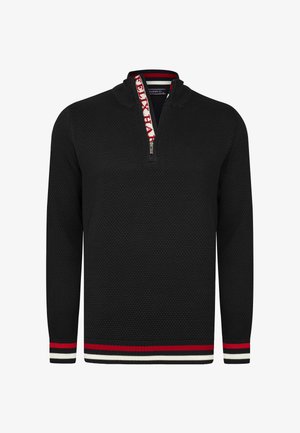 Schwarzer strukturierter Pullover mit einem halben Reißverschlusskragen, der mit einem gemusterten rot-weiß-blauen Streifenbesatz entlang des Kragens und der Ärmel versehen ist.