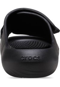 Des Crocs noirs à dos fermé, fabriqués en matériau durable, avec une surface texturée et une semelle intérieure rembourrée dotée de perforations.