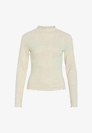 Cream-colored long-sleeve top made of ribbed fabric, featuring a high ruffled neckline and a scalloped hem.