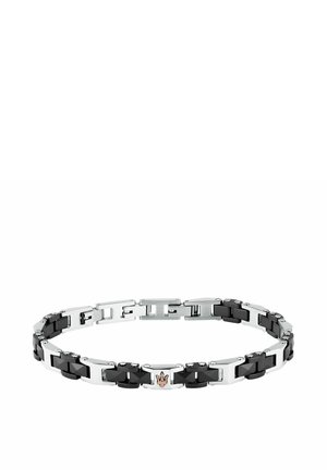 Bracciale argentato e nero con piccoli borchie metalliche e un emblema centrale a tridente dorato su sfondo bianco.