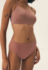 Rose-colored bra and matching high-waisted underwear. The fabric is smooth with a slight texture. The bra has thin straps and seamless design.