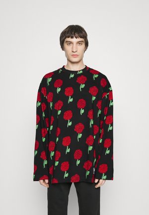 Ilga rankovė juoda marškinė su pakartotiniais raštais iš raudonų rožių ir žalių lapų. Minkšta medžiaga ir laisvas fasonas, apvalus kaklas.