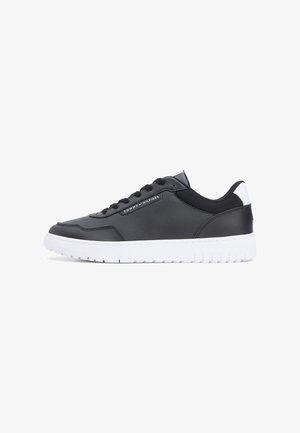 Black synthetic sneaker with a smooth upper, white sole, round toe, and perforated details. Features black laces and a logo accent on the side.