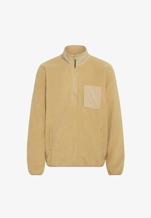 Bež flis pulover z zadrgo do polovice spredaj, visokim ovratnikom in kvadratno žepno torbico. Vključuje stranske žepe in elastične manšete. Mehka tekstura.