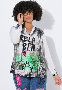 Chemise blanche à manches longues avec imprimé tropical noir et texte de style graffiti. Dotée d'un col en V et d'une coupe décontractée. Silhouette ample et texture douce.