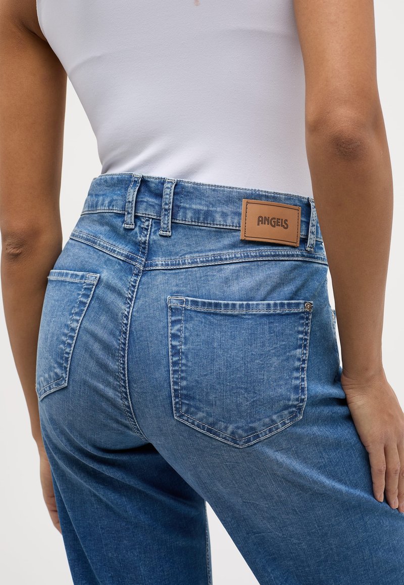 Blauwe denim jeans met een hoge taille, voorzien van een tan lederen patch met het label "ANGELS" en twee achterzakken met zichtbare stiksels.