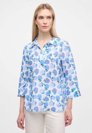 Lyseblå skjorte med et blomsterprint i forskellige nuancer af blå og grøn, med krave og ærmer i trekvart længde.