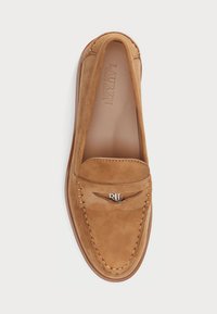 Brown suede loafers with a rounded toe, decorative stitching, and a metal logo accent on the vamp. Smooth interior lining.
