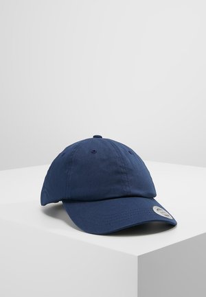 Marineblå bomuldsbaseballkasket med en buet skygge, syede detaljer og en rund logo-patch på siden. Blød tekstur, ustruktureret design.
