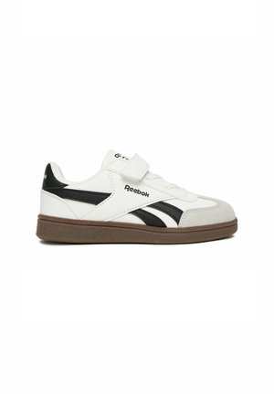 Biało-czarny but sportowy Reebok z brązową podeszwą, paskiem na rzep i logo Reebok z boku i z tyłu, widziany z boku na białym tle.
