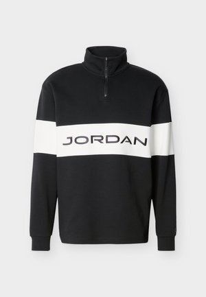 Sudadera negra de manga larga con una raya horizontal blanca en el pecho y el texto "JORDAN", con un cuello alto de cremallera parcial.