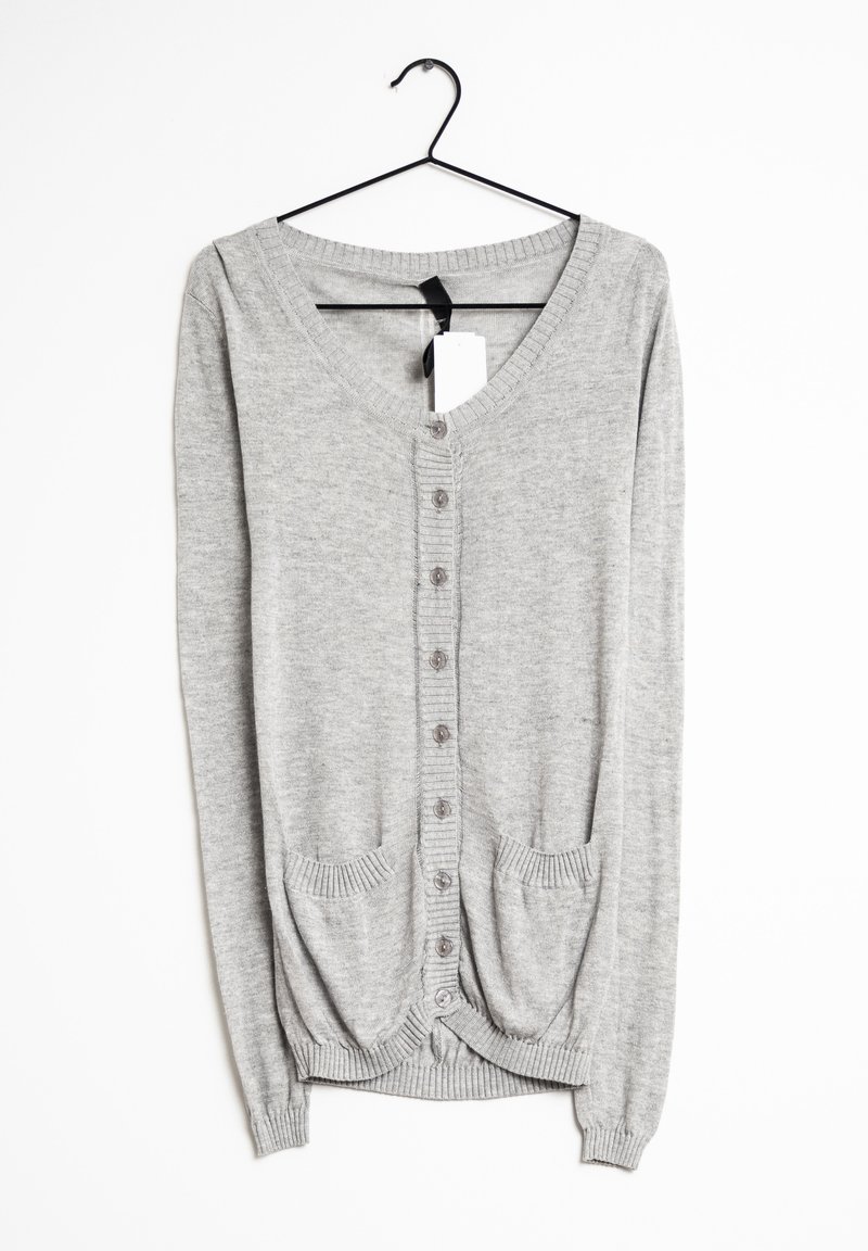Grå långärmad kofta med V-hals, knäppning framtill, ribbade ärmslut och två framfickor. Slät stickad textur och justerbar längd.