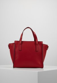 Rote Leder-Tote-Tasche mit doppelt genähten Obergriffen, strukturiertem Design, feinen Nähten und schwarzen Akzenten. Glatte Textur, minimalistisches Design.
