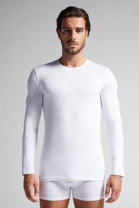 Witte langemouwen top, strakke snit, gladde textuur, ronde halslijn. Gecombineerd met witte strakke boxershorts. Eenvoudig zonder patronen of accenten.